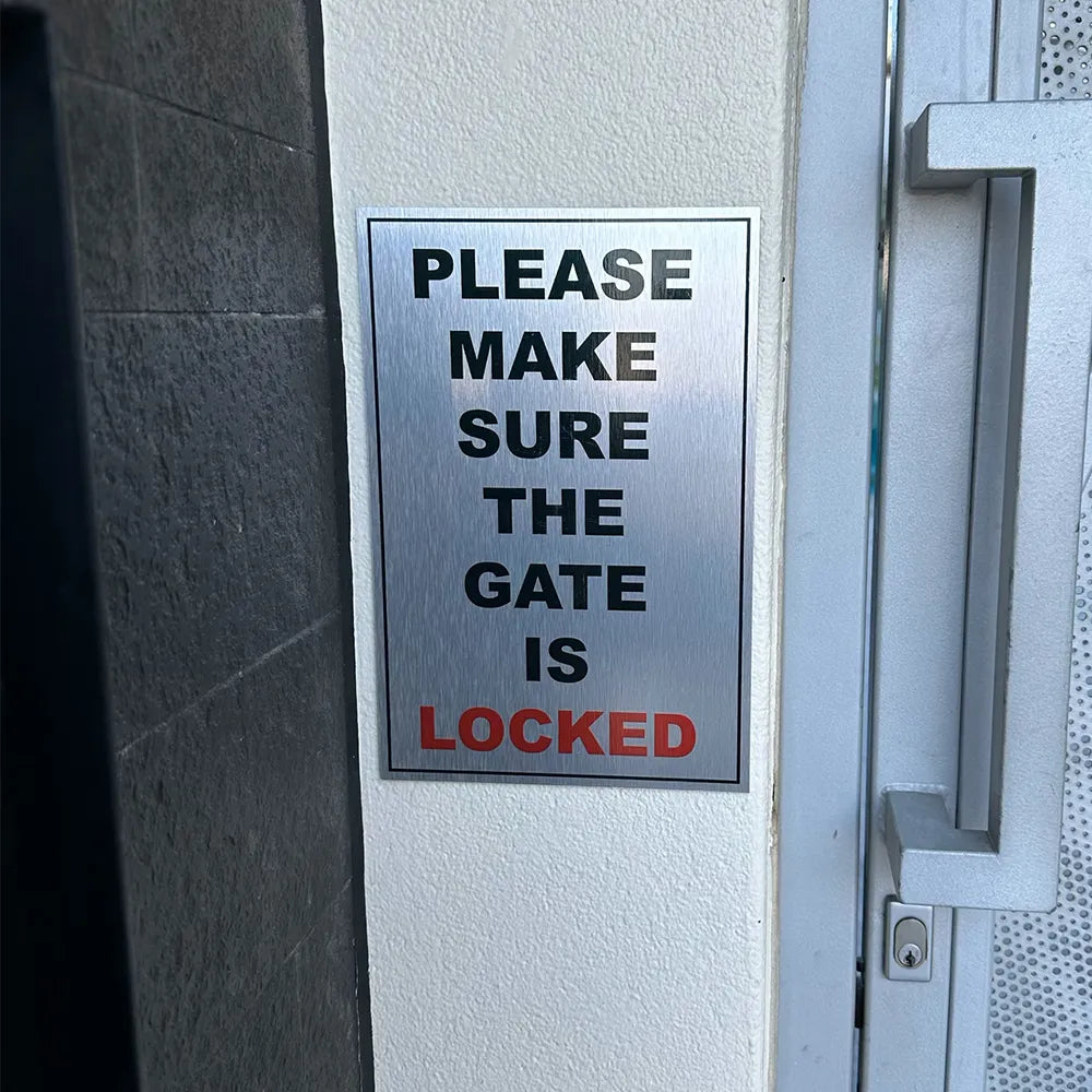 Brushed metal sign displayed on rendered entry wall.
