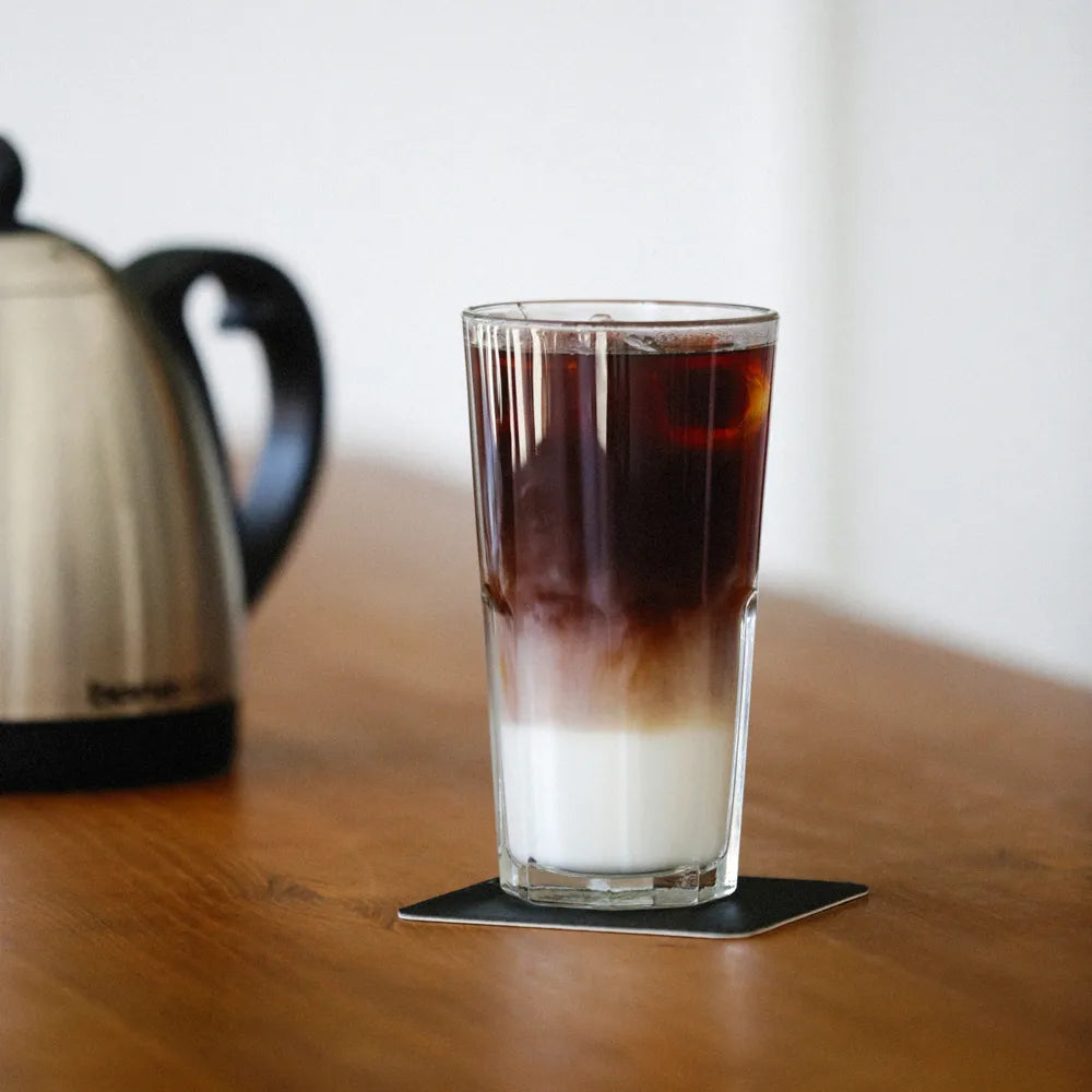 Iced coffee resting on a drink coaster with a promotional message